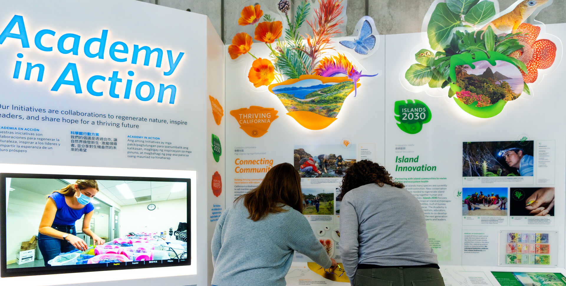 2 guests look at the new exhibition kiosk, Academy in Action