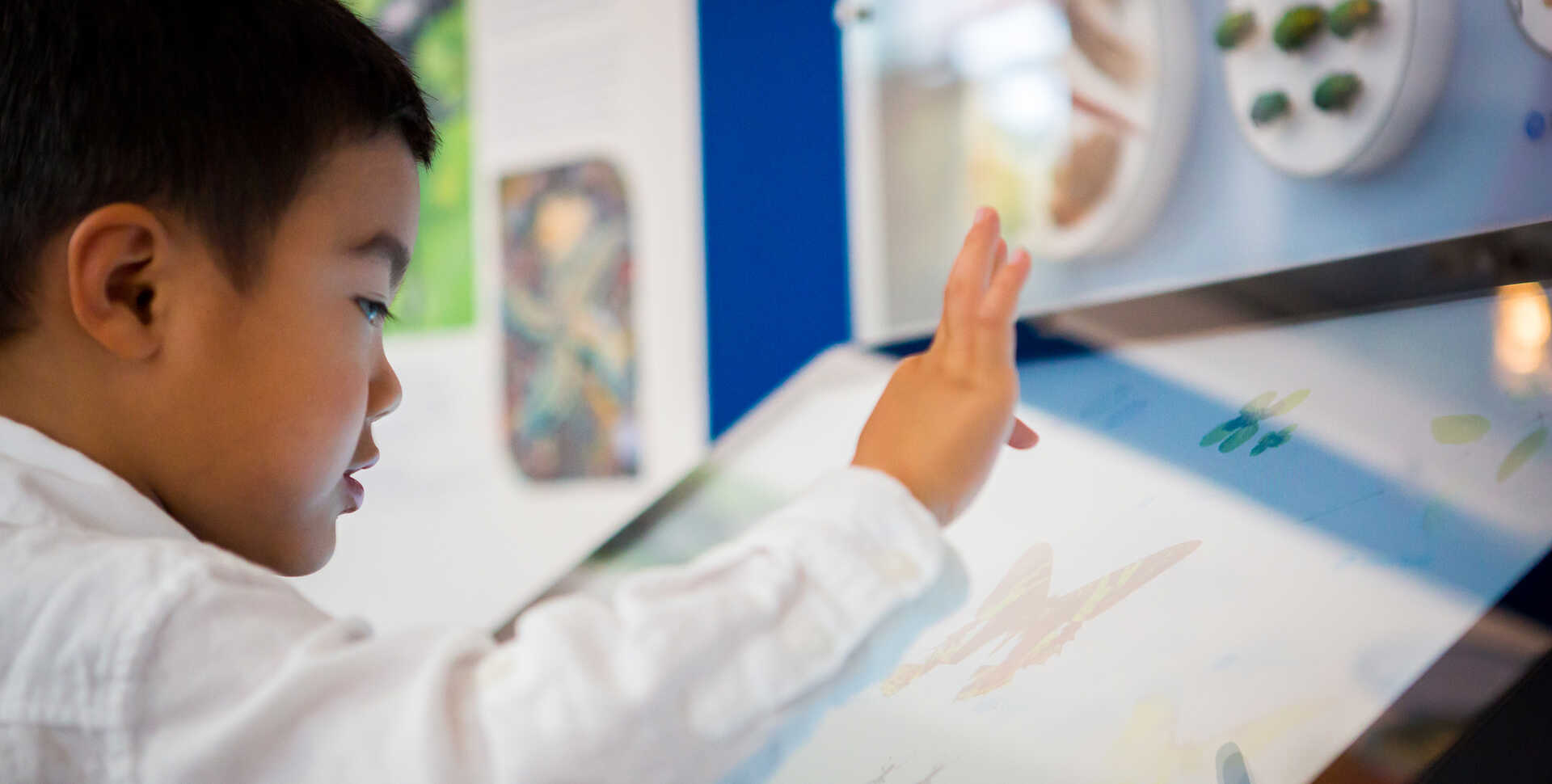 A young visitor explores the Macro Color magnifier on exhibit at the Academy