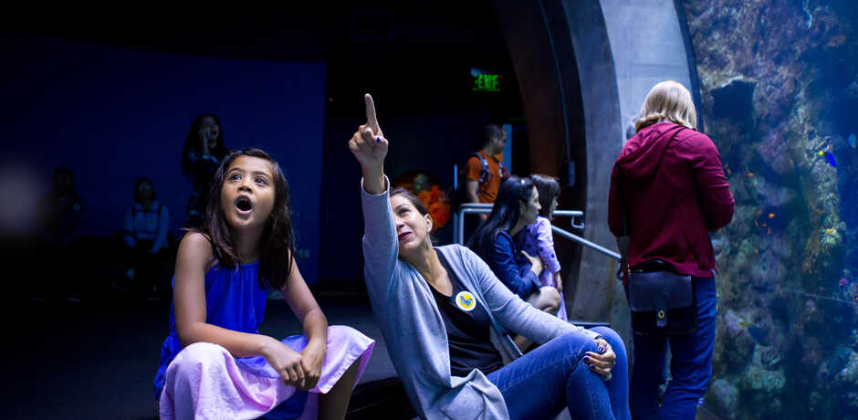 A woman shows an amazed young girl the Philippine Coral Reef exhibit
