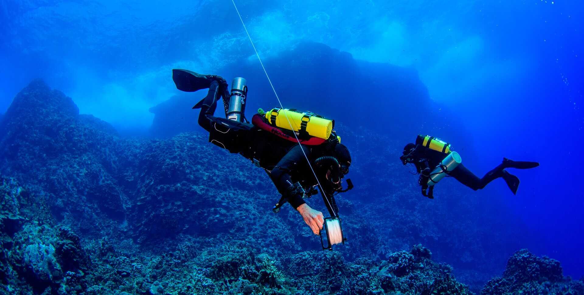 2 scuba divers lay transect lines in Easter Island